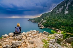 female-trekker-resting-on-a-cliff-in-olympos-PDNANFM Contemplation about life Meditation Online